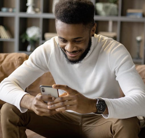 A man who is enjoying his time texting with someone on his Apple iPhone.